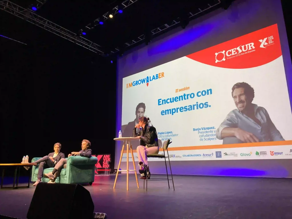 Encuentro con empresarios en el Auditorio Cartuja, con ponentes sentados en el escenario durante la sesión de IMGROWLABER y CESUR